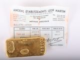 un lingot d'or posé à côté d'un ticket de caisse sur une table