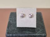 une paire de boucles d'oreilles en diamant posée sur un bloc de marbre