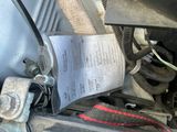 a close up of a car ' s engine with a paper attached to it