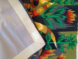 an image of a close up of a bed with a colorful comforter