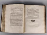 an open book on a table with a picture of a crown on it