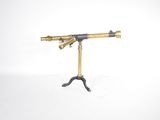 an antique brass telescope on a tripod stand on a white background