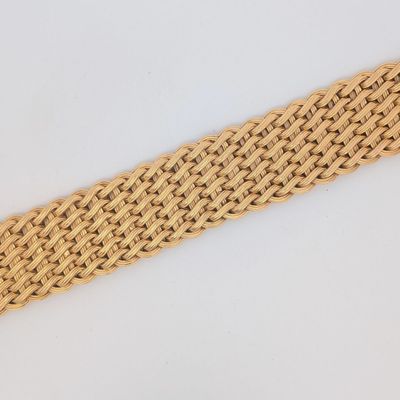 un gros plan d'un bracelet tressé posé sur une surface blanche