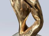 statue of two hands holding each other on a marble base