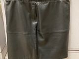 une jupe en cuir noir suspendue à un cintre dans une cuisine