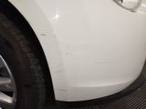 a close up of a white car with a denting on it