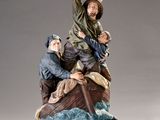 figurine of a man in a boat with two men on it