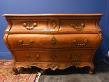 une commode dans une pièce où il y a un tapis au sol