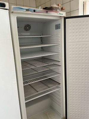 a white refrigerator with its door open in a kitchen