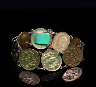 un gros plan d'un bracelet orné de pièces de monnaie sur un fond noir