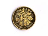 une pièce d'or ornée de fleurs sur un fond blanc