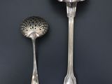 two spoons and a spoon rest on a black surface