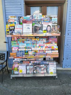 un présentoir de magazines sur un chariot à l'extérieur d'un bâtiment