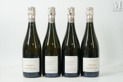 quatre bouteilles de vin sont alignées sur une surface blanche