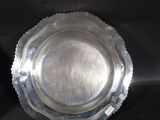 a silver plate on the table with a black background
