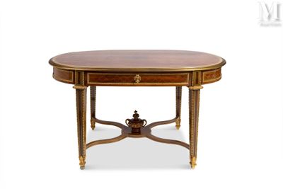 une table à manger ovale avec un plateau en bois et des finitions dorées