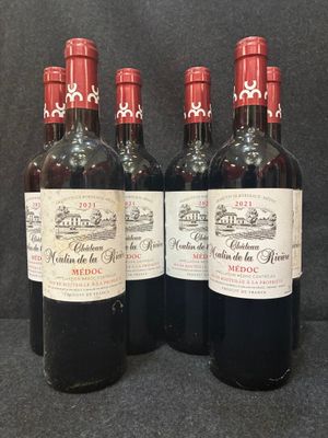 quatre bouteilles de vin sont alignées sur une surface noire