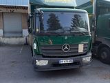deux camions verts garés l'un à côté de l'autre devant un immeuble