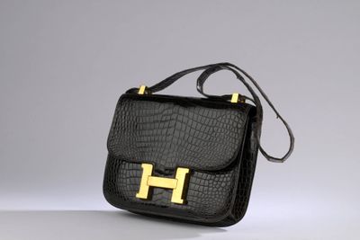 a black handbag with a gold h on the front