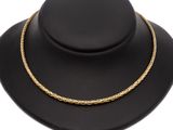 a gold rope necklace on a black mannequin