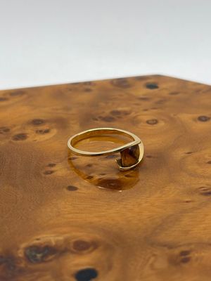 une photo d'une bague en or posée sur une table en bois