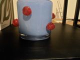 une tasse bleue à pois rouges posée sur une table