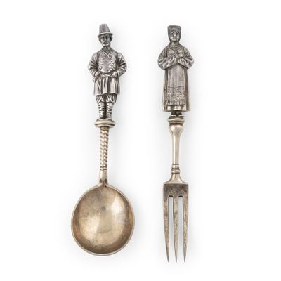 deux cuillères et une fourchette surmontées d'une statuette
