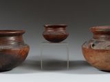 three brown vases sitting on top of a table next to each other