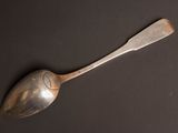 silver spoon on a black surface with a black background
