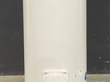 a white water heater sitting on the floor in front of a black wall