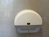 a toilet paper dispenser and a roll of toilet paper