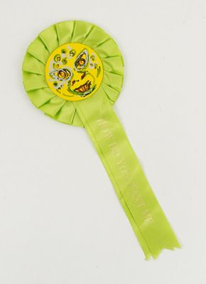 a close up of a green ribbon with a yellow rosette on it
