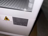 a small white refrigerator with a sign on the door