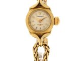 an image of a woman ' s wrist watch with a chain around it