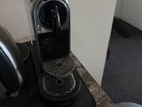 une cafetière en argent posée sur un plan de travail à côté d'une autre cafetière en argent