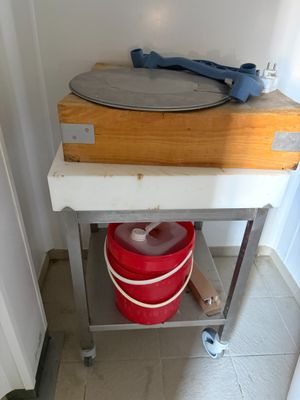 un seau rouge posé sur une table en métal à côté d'un autre seau rouge