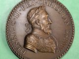an image of a bronze coin with a man ' s head on it
