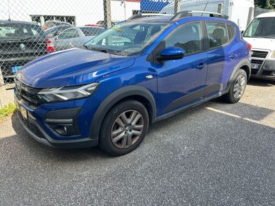 a blue car parked in a parking lot next to a fence