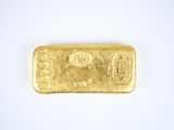 a close up of a gold bar on a white surface