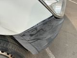 a car that has been dented and is parked on the side of the road