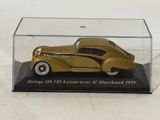 an image of a gold model of a car in a glass case
