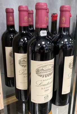 six bouteilles de vin rouge sont exposées dans une vitrine