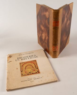 un vieux livre posé sur une table blanche à côté d'un livre