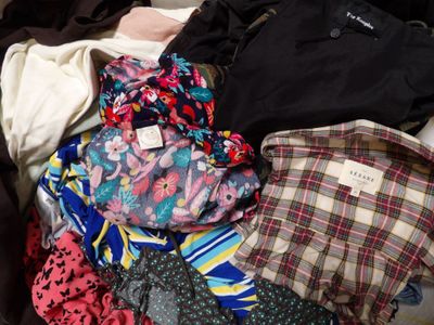 a suitcase full of clothes and ties sitting on the floor