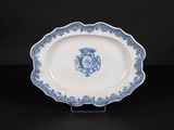 an antique blue and white platter with a crest on it