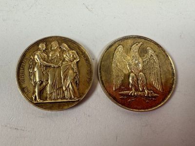 two gold coins with angels on them sitting next to each other