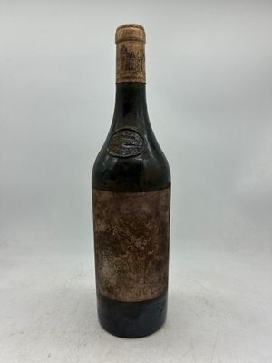 une bouteille de vin posée sur une table blanche
