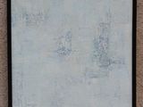 tableau accroché au mur d'une pièce, dans un cadre noir, représentant un tableau blanc et bleu