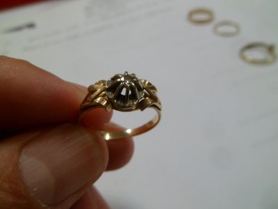une personne tenant une bague en or ornée d'un diamant noir