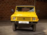 a yellow truck that is parked in front of a brick wall